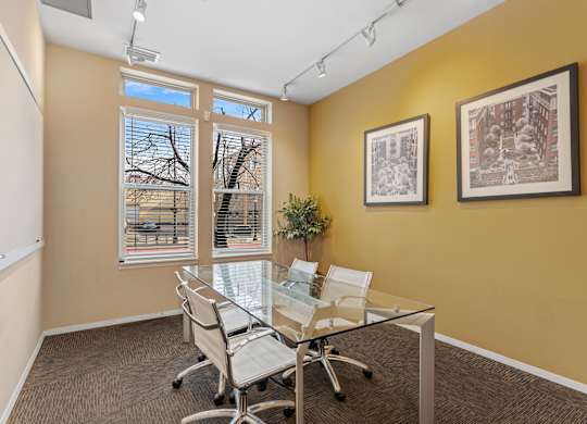 A conference room with a glass table and chairs.