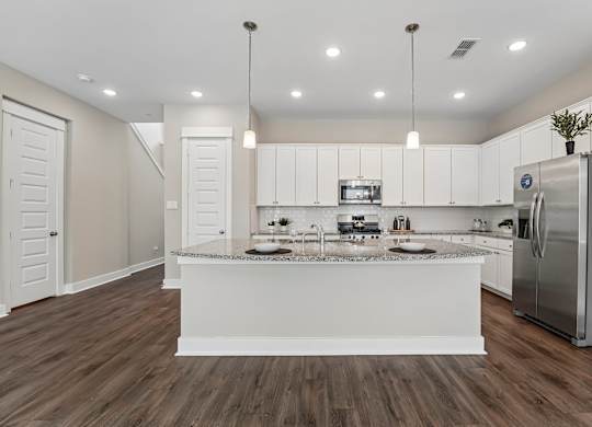 A modern kitchen with white cabinets and a central island.