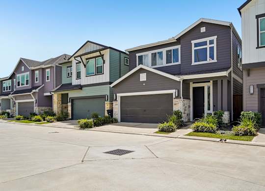A row of houses with garages in front.