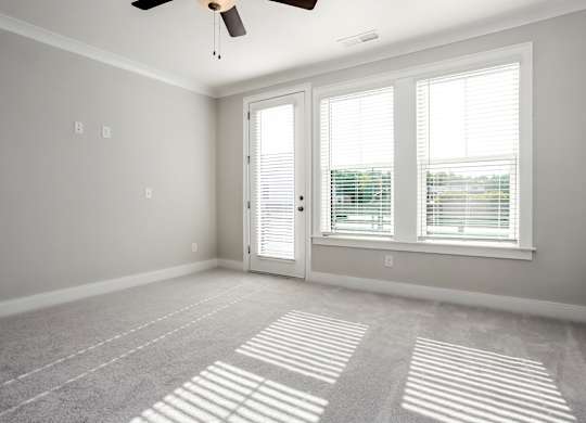A room with a ceiling fan and a carpeted floor.