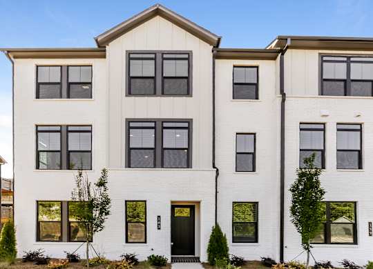 A white two-story house with black doors and windows.