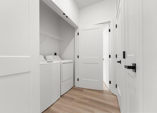 A white laundry room with a washer and dryer.