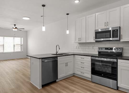A modern kitchen with white cabinets and stainless steel appliances.