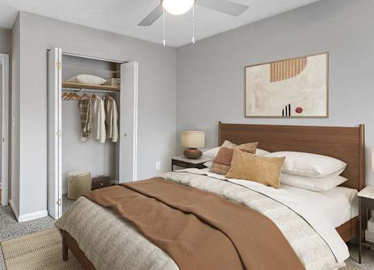 A bedroom with a large bed and a closet with clothes hanging.