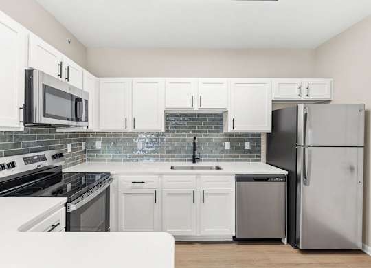 A kitchen with white cabinets and appliances.
