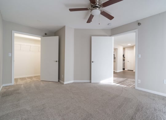 an empty living room with a ceiling fan