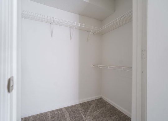 an empty room with white walls and a white closet