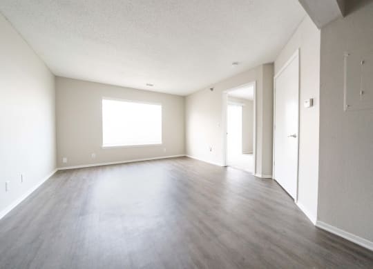 an empty living room with wood floors and white walls