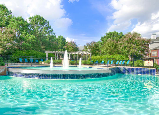 Enclave at Wolfchase Apartments in Cordova Tennessee photo of a fountain in the middle of a pool with a pergola in the background