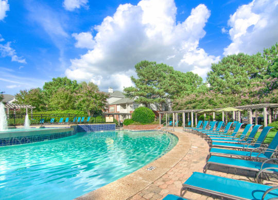 Enclave at Wolfchase Apartments in Cordova Tennessee photo of a resort style pool with chaise lounge chairs and a fountain