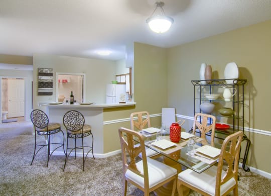 Enclave at Wolfchase Apartments in Cordova Tennessee photo of a dining room with a table and chairs and a kitchen in the background