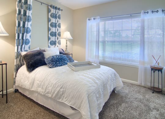 Enclave at Wolfchase Apartments in Cordova Tennessee photo of a bedroom with a bed and two windows