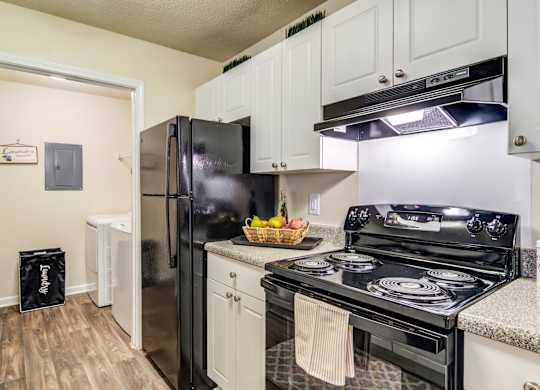 Kitchen with black appliances at Ashford at Spring Lake in Atlanta, Georgia