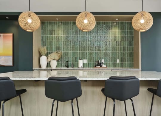 a bar with blue chairs and a large mirror in a hotel room