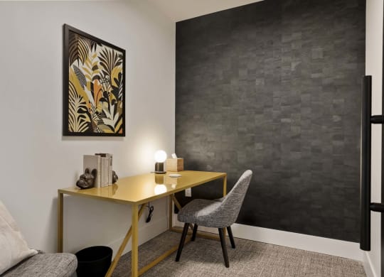 a home office with a desk and a chair and a painting on the wall