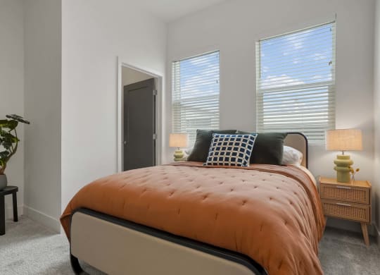 a bedroom with a bed and three windows