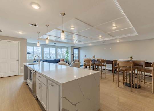 A kitchen with a marble island and wooden floors.