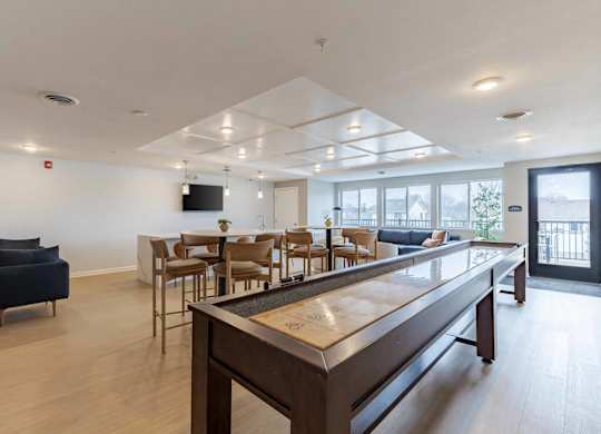 A modern living room with a long wooden table and chairs.