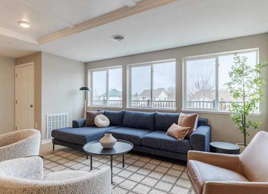 A living room with a blue couch and a round table.
