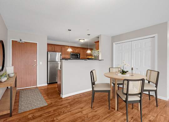 a dining room and kitchen with a table and chairs and a refrigerator