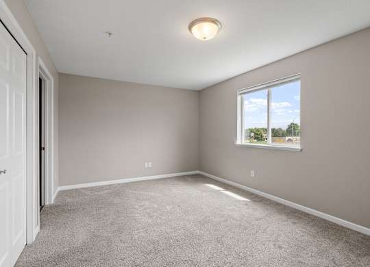 an empty room with carpet and a window