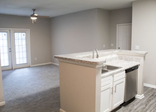 Enclave at Wolfchase Apartments in Cordova Tennessee photo of a kitchen with an island and an empty living room in the background