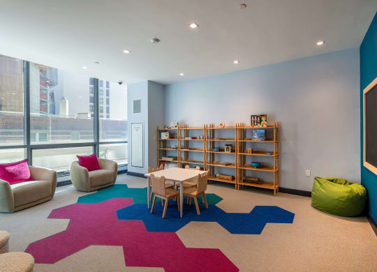 a play room with a table and chairs and a large rug