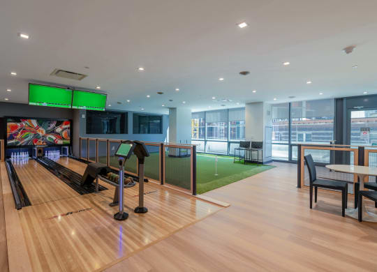a bowling alley in a building with bowling lanes and tables