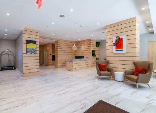 the lobby of a hotel with chairs and a desk