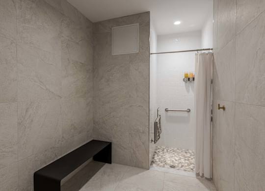 A bathroom with a marble wall and a bench.