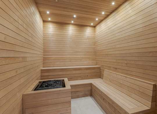 A wooden sauna with benches and a hot tub.