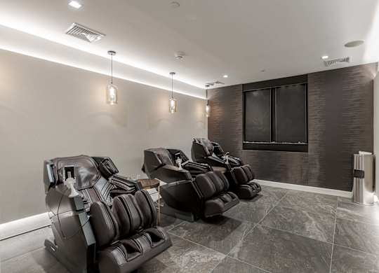 A row of black leather chairs are lined up in a room.