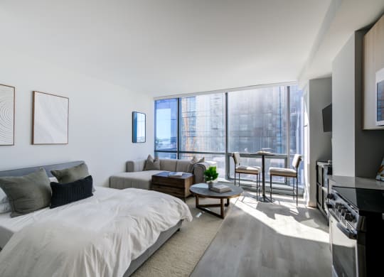 a bedroom with a bed and a couch and a large window
