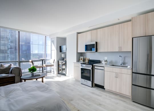 a bedroom with a bed and a kitchen with a refrigerator