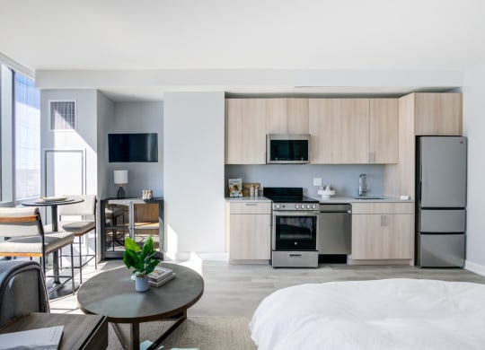 a bedroom with a bed and a kitchen with a refrigerator