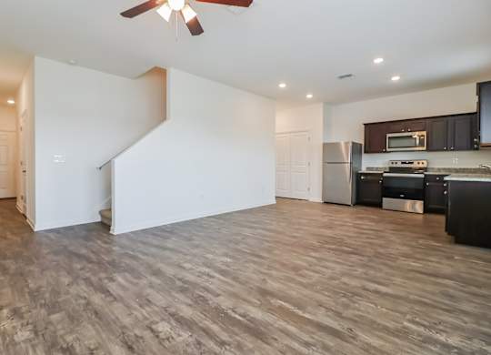 A spacious kitchen with a refrigerator, microwave, and oven.