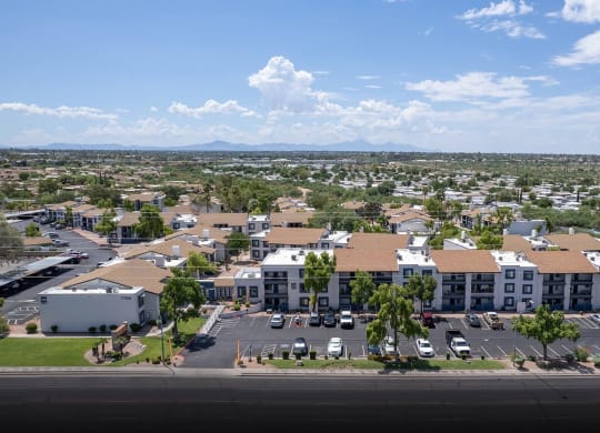 an aerial view of an apartment complex with cars parked in a parking lot