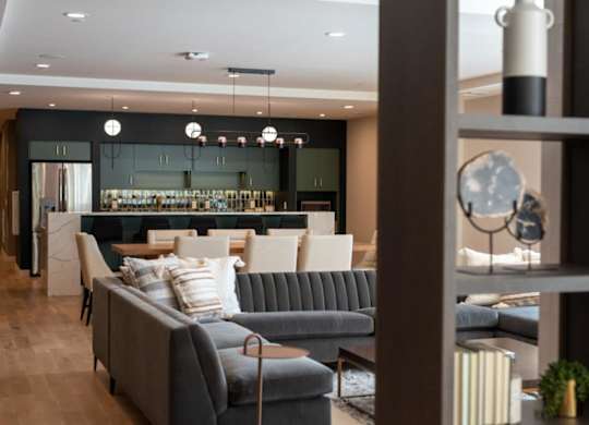 A grey sofa with a striped pillow is in the middle of a room.