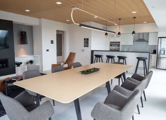 A modern dining room with a large table and chairs.