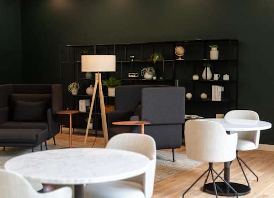 A modern living room with a white table and black and white chairs.