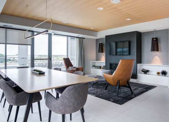 A modern dining room with a large table and chairs.