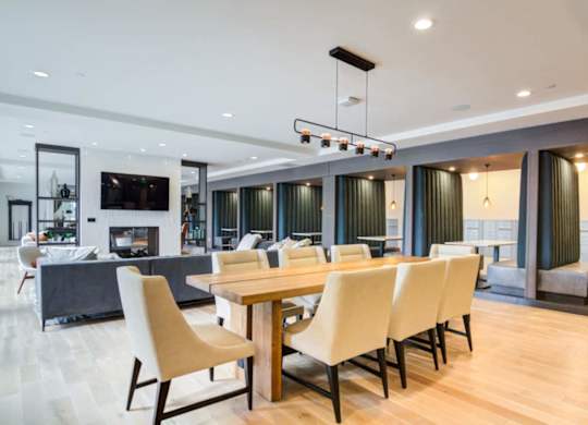 A modern dining room with a long table and chairs.
