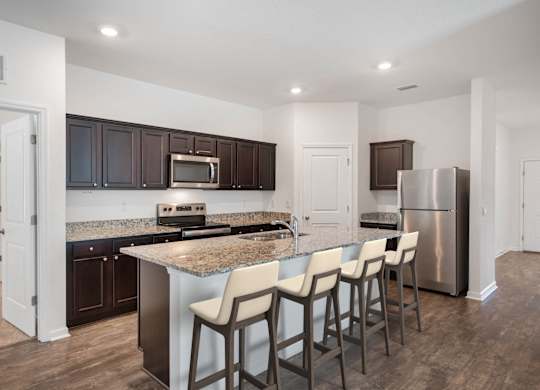 A kitchen with a granite countertop and stainless steel appliances.