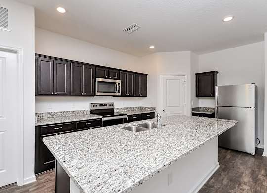 A kitchen with granite countertops and stainless steel appliances.