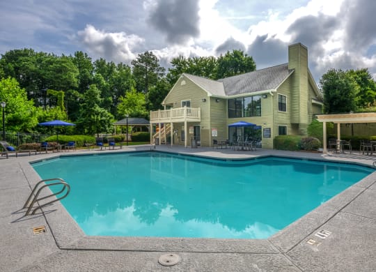 a swimming pool with a house in the background