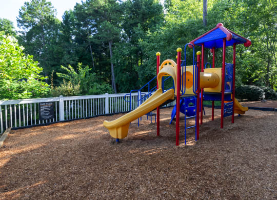 a childrens playground with a slide at a park