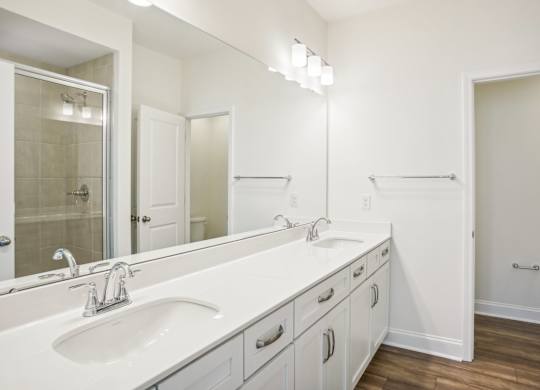 a white bathroom with two sinks and a mirror