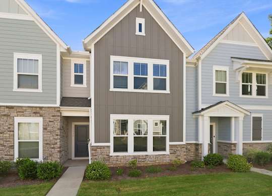 A row of houses with different shades of grey and white.