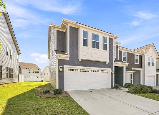 A modern two-story house with a garage is shown in the image.
