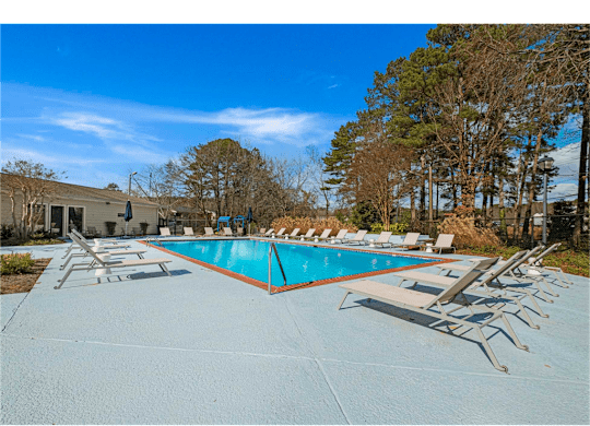 Resort-style pool area with lounge chairs at Springdale Glen, a pet-friendly community in Clarkston, GA, near Decatur, perfect for relaxation and socializing.